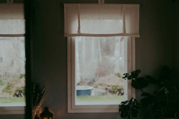 vit rullhissgardin i linne hänger i fönster.