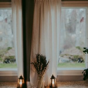 Ecological white Linen curtains hanging in cozy window.